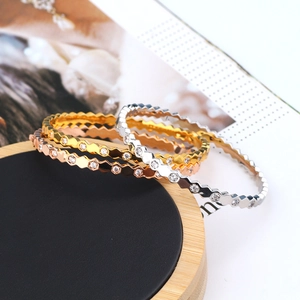 Macro detail of geometric hexagonal bracelets with micro-set zircons in three metal tones