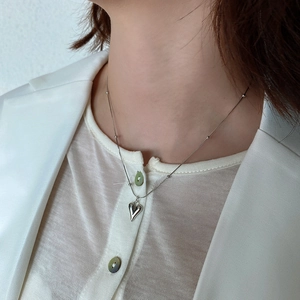 Close-up of minimalist 925 silver heart necklace on neck featuring beaded chain design