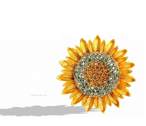 Detailed view of sunflower brooch with intricate gold texture and crystal centers