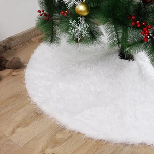 White plush Christmas tree skirt on wooden floor with festive holiday decorations