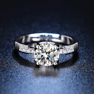 Detailed macro view of silver four-prong solitaire ring with side stones and open band
