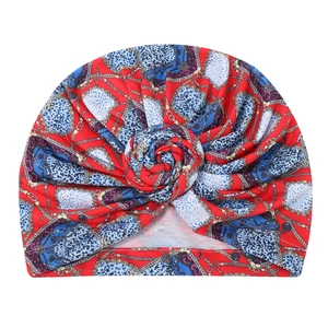 Close-up of printed turban hat with chain and leopard patterns and front twist detail