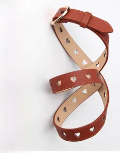 Detail of red-brown leather belt featuring heart-shaped cutouts and gold buckle