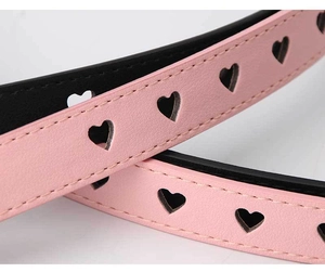 Detailed view of pink PU leather belt featuring decorative heart-shaped punch holes