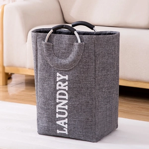 Large gray laundry basket with aluminum handles and laundry text on home background