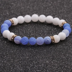 Close-up of 8mm white stone beads and blue veined stones bracelet with gold spacers