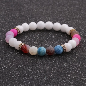 Detailed macro view of 8mm white stone beads bracelet with colorful accents and gold spacers