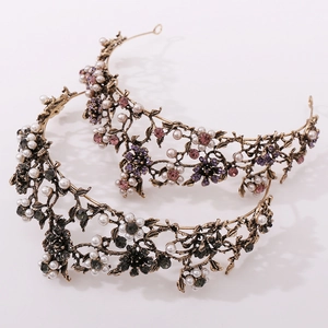 Close-up of vintage floral crowns with black diamonds, pearls, and crystals on gold metal
