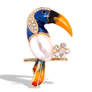 Exquisite gold toucan bird brooch with blue enamel, large pearl, and rhinestone accents