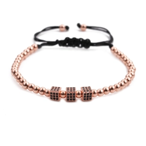 Detail of rose gold bracelet with black zircon cubes and adjustable woven cord strap