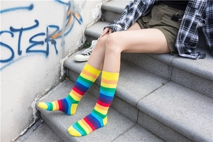 Detailed street-style shot of rainbow striped high socks on a model in urban setting
