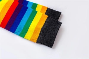 Close-up detail of cotton rainbow striped socks with elastic dark grey ribbed cuffs