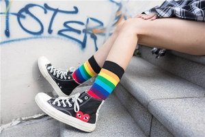 Detail of colorful rainbow striped high socks worn with casual street style footwear
