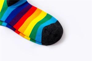 Detailed close-up of rainbow striped cotton socks showing knitted texture and dark grey toe