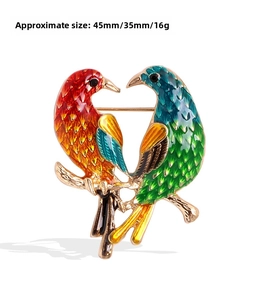 Detail of colorful enamel bird brooch with rhinestones on golden branches, 45mm size
