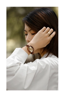 Close-up of elegant small square lady watch with brown leather strap on model wrist