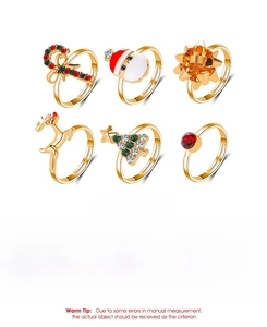 Close-up of 6-piece Christmas ring set with elk and tree charms on white backdrop
