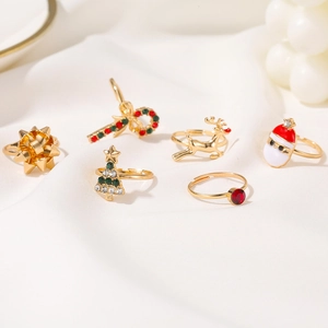 Close-up of a 6-piece Christmas ring set with enamel Santa and reindeer on white silk