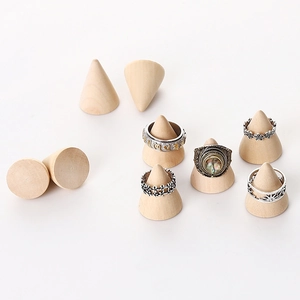 Cone-shaped solid wood ring stands showcasing vintage metal rings on white background