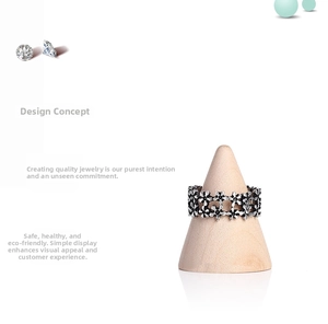 Close-up of vintage floral silver ring on a conical wooden jewelry display stand