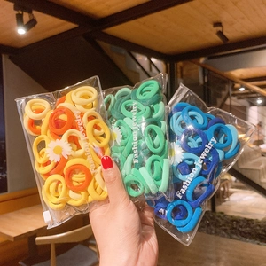 Close-up of elastic hair ties in yellow, green, and blue colors in zipper bags