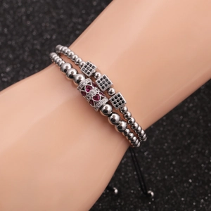 Silver bead bracelets set with red heart charm and black cubic zirconia cubes on wrist
