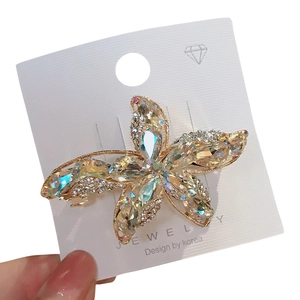 Golden starfish hair clip with rainbow K9 crystals and rhinestones on jewelry card