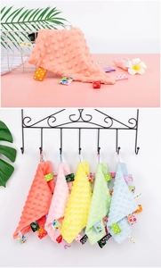 Detail showing plush dotted fabric texture and colorful patterned ribbon tags for babies