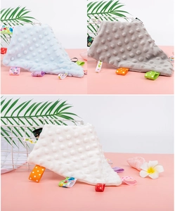 Detail view of baby security blankets with 3D dotted minky fabric and colorful tags