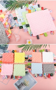 Close-up of baby sensory tag security blanket showing 3D dot fabric and colorful ribbon tags