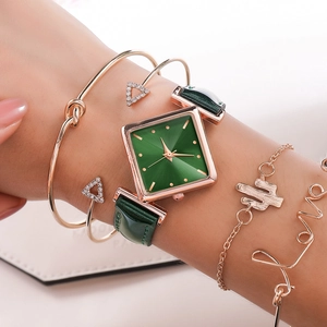 Close-up of women's square green dial watch set with gold bracelets and leather strap