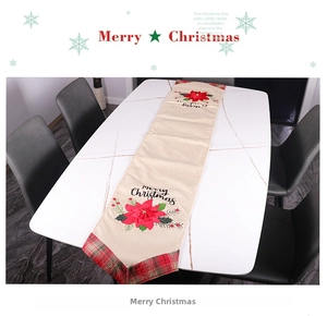 Detail of Christmas table runner with red poinsettia embroidery and plaid pattern ends