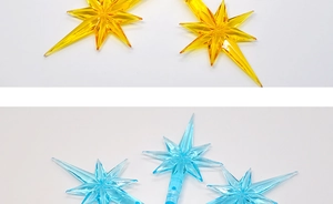 Macro detail of star-shaped ceramic Christmas tree bulb decorations in yellow and blue colors