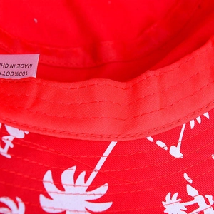 Red cotton sun hat with white palm tree prints and wide brim for summer beach travel