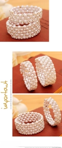 Detail show of multilayer pearl spiral bracelet with rhinestone spacers on a wooden desk