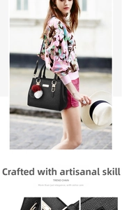 Close-up of black lychee grain leather handbag with iconic tricolor pompom charm
