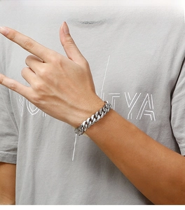 Detail shot of a silver Cuban link bracelet in stainless steel on a male model's wrist