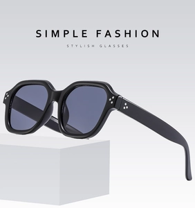 Detail of black irregular square sunglasses with silver triple rivet hinges and grey lenses