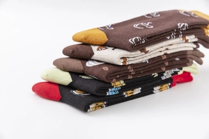 Detail view of cotton crew socks featuring knitted coffee cup patterns in earth tones