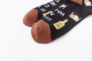 Detail of funny cotton socks with 'IF YOU CAN READ THIS BRING ME WHISKEY' text and icons