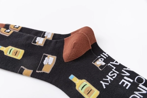 Detail of knit cotton socks with funny whiskey bottles and 'Bring Me Whiskey' text