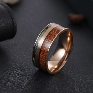 Detail view of 9mm rose gold titanium ring with koa wood and abalone shell inlay