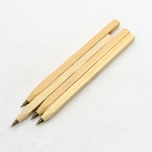 Close-up of square wooden ballpoint pens with printed ruler scales and brass tips