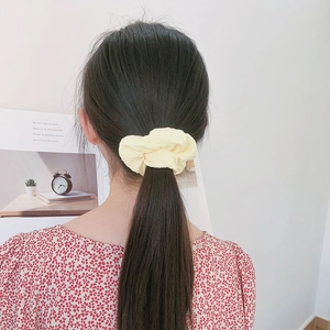 Ανοιχτό κίτρινο λαστιχάκι μαλλιών από ανάγλυφο ύφασμα σε χτένισμα αλογοουράς