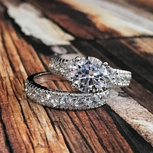 Luxuriöses Zirkon Brautset mit Verlobungsring und Ewigkeitsring auf Holz Hintergrund