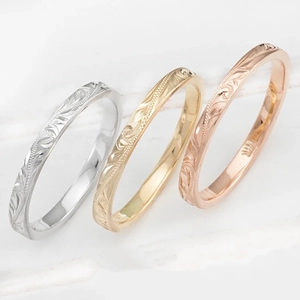Vista detallada de tres anillos con grabado floral hawaiano en oro y plata fina