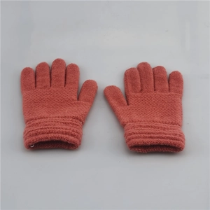 Close-up of pink knit gloves for kids with ribbed cuffs on a light grey background