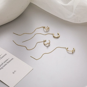 Dettaglio del set di quattro ear cuff dorati con stelle e croci in zircone lucido