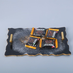Close-up of fluid art resin tray with irregular edges and gold cylinder metal handles