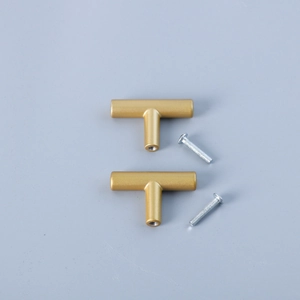 Macro shot of two matte gold T-bar cabinet handles with matching screws on blue background
